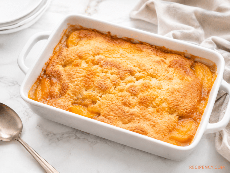 Golden baked Peach Cobbler with Cake Mix in a white ceramic baking dish