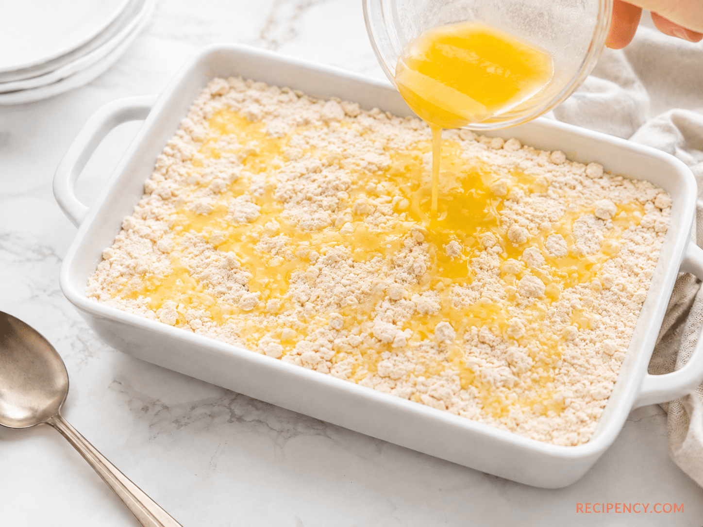 Melted butter drizzled over the dry cake mix in the baking pan