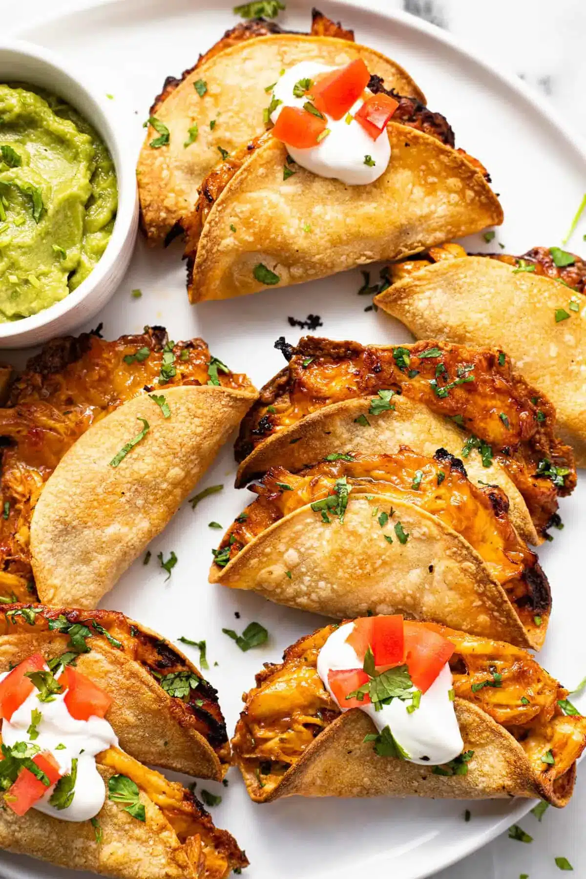 20-Minute Mini Tacos (Crispy Baked Chicken Tacos) 17 Plate of Mini Tacos topped with sour cream and diced tomatoes