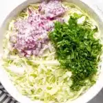 5-Minute Cilantro Lime Slaw 5 White bowl containing shredded cabbage, red onion, and cilantro for Cilantro Lime Slaw