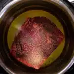 Easy Instant Pot French Dip 5 Raw chuck roast placed in the Instant Pot with heated olive oil