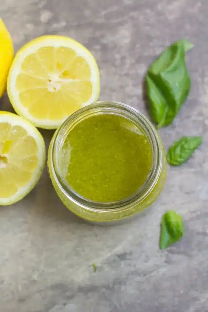 Healthy Lemon Basil Vinaigrette 8 Close-up overhead shot of bright green Lemon Basil Vinaigrette emulsified in a clear glass jar.