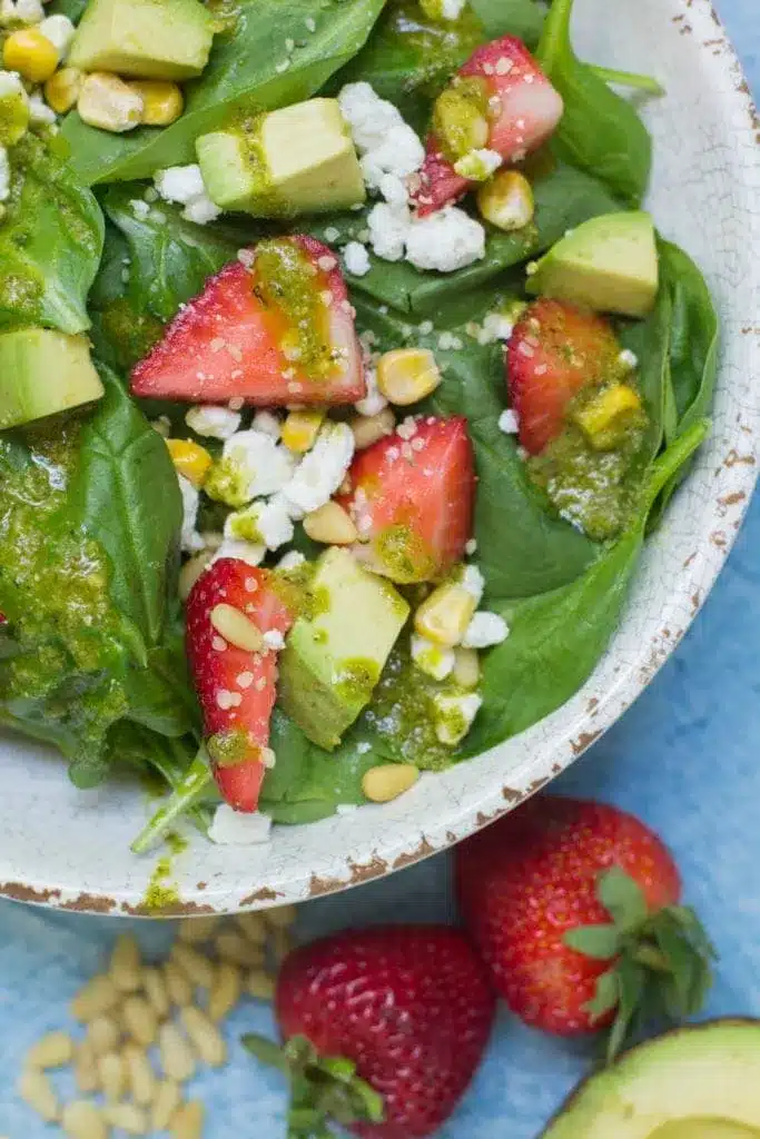 Healthy Lemon Basil Vinaigrette 10 Overhead view of a strawberry spinach salad with avocado and goat cheese, drizzled with Lemon Basil Vinaigrette.