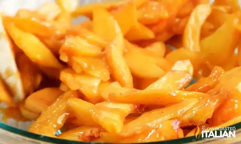 The Best Southern Peach Cobbler 7 Fresh peach slices being tossed with brown sugar and spices for the Southern Peach Cobbler + Video filling.