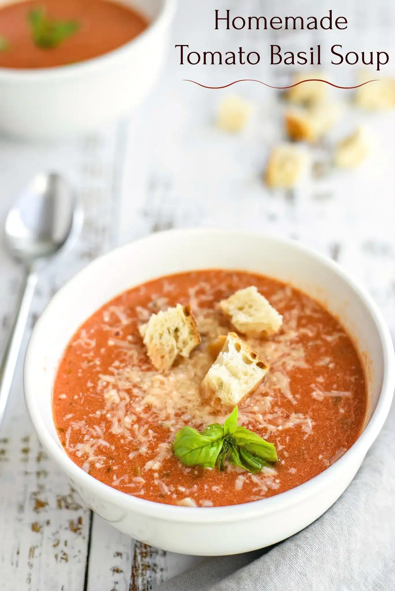 Tomato Basil Soup 10 A rustic bowl of Tomato Basil Soup served with a side of crusty bread and a dusting of Parmesan.