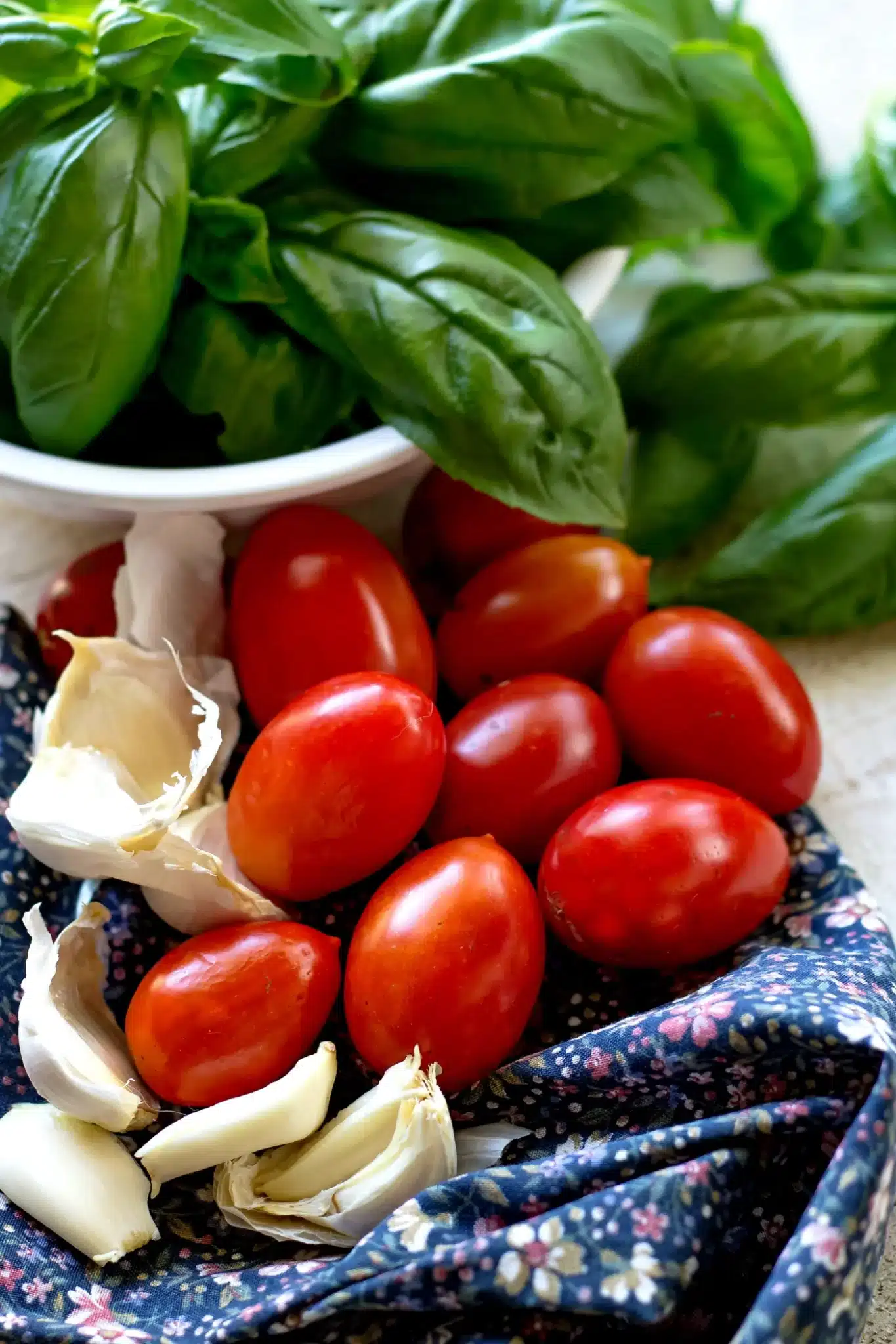Chopped plum tomatoes and fresh basil leaves arranged on a cutting board for the Tomato Basil Vinaigrette