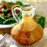 Drizzling homemade Tomato Basil Vinaigrette over a fresh green salad
