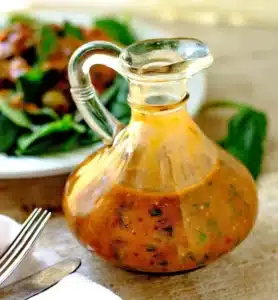 Drizzling homemade Tomato Basil Vinaigrette over a fresh green salad